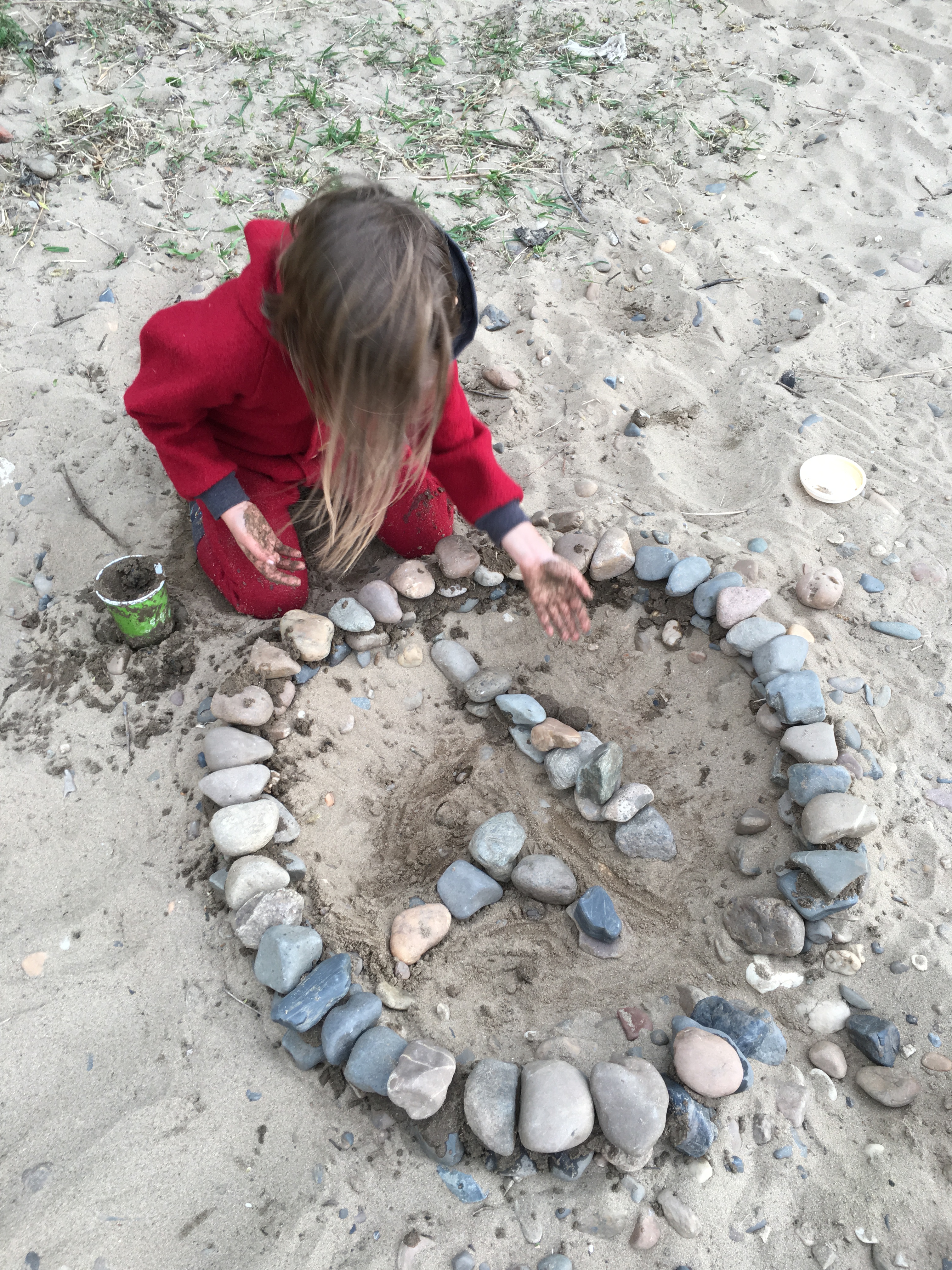 Kind legt Steinkreis