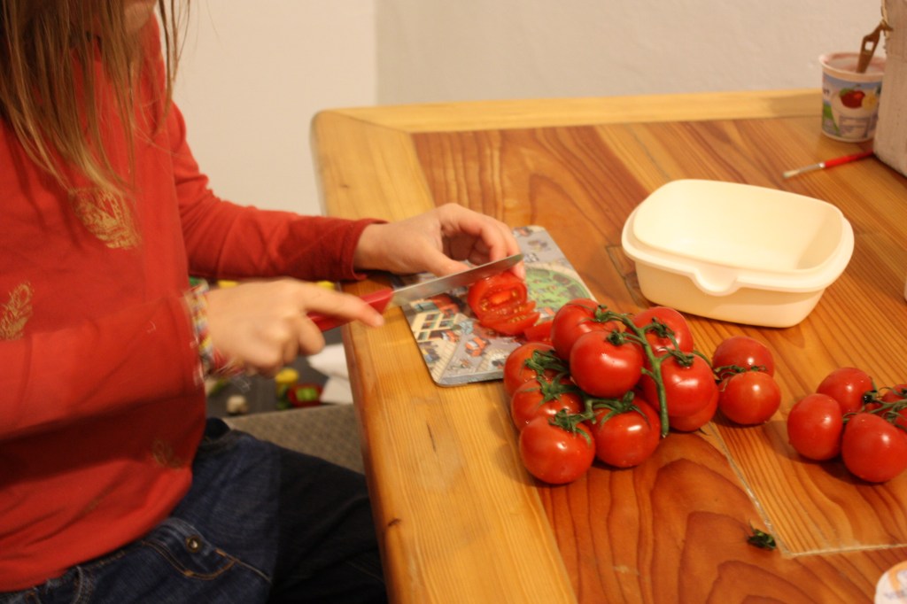 Kind schneidet Tomaten