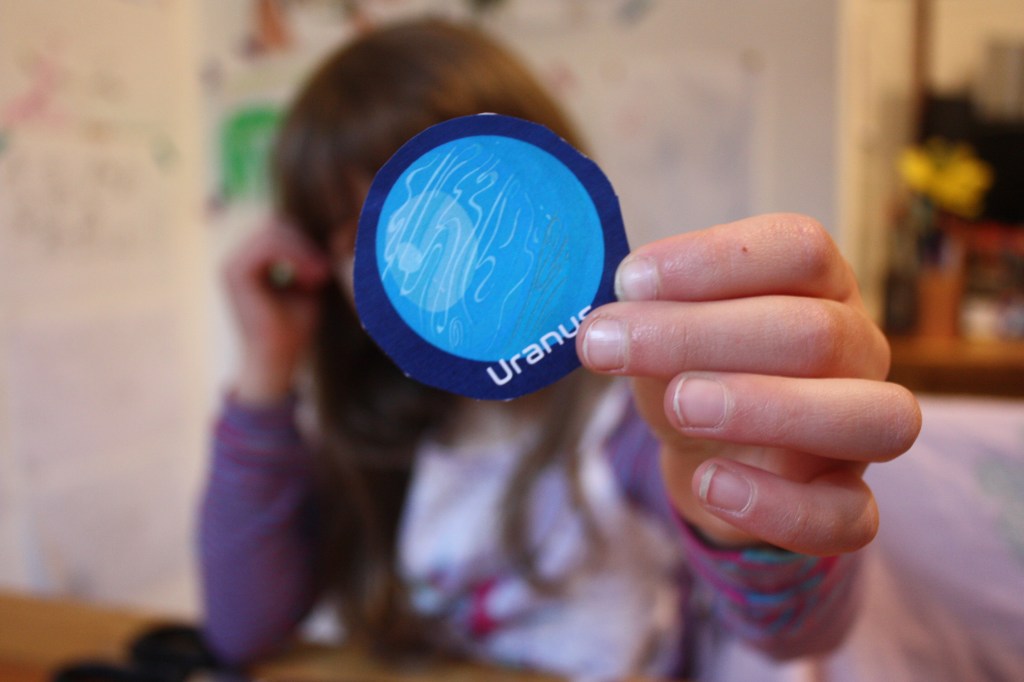 Kind hält Uranus aus Papier