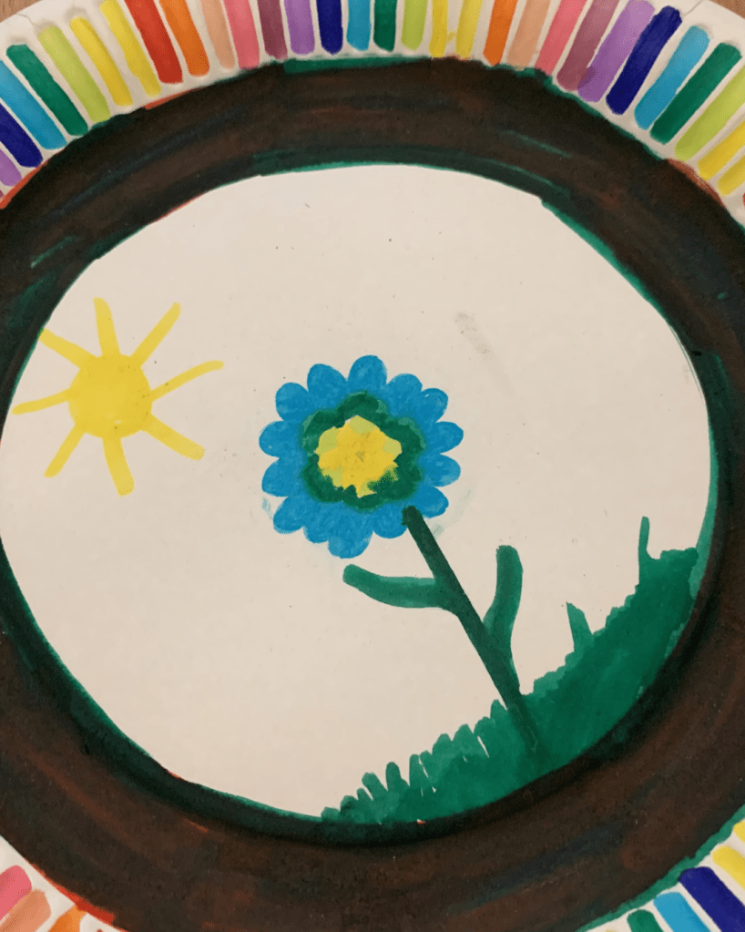 Blaue Blume auf Pappteller gemalt