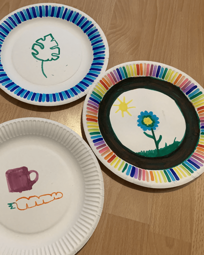 Drei von Kindern bemalte Pappteller