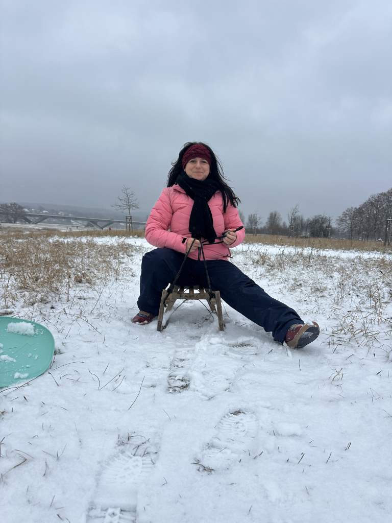 Frau auf Schlitten im Schnee