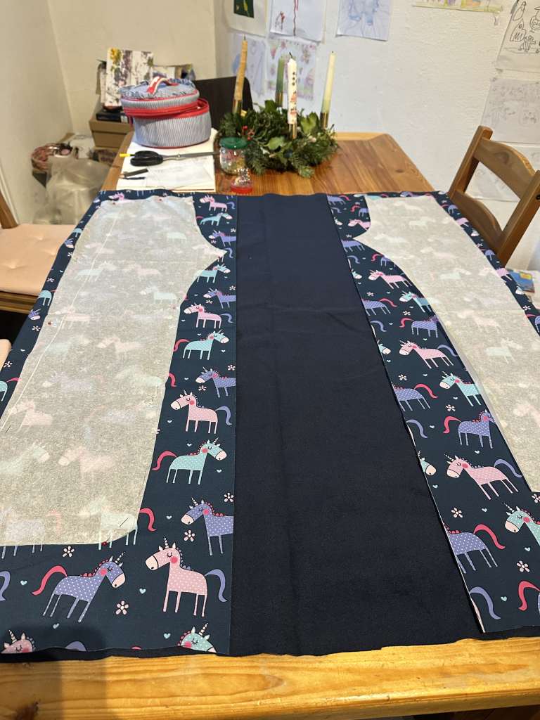 Einhorn-Stoff, auf dem Schnittmuster liegen