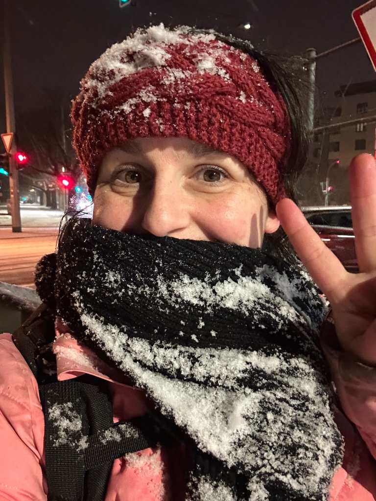 Frau mit Stirnband und Schal voller Schnee