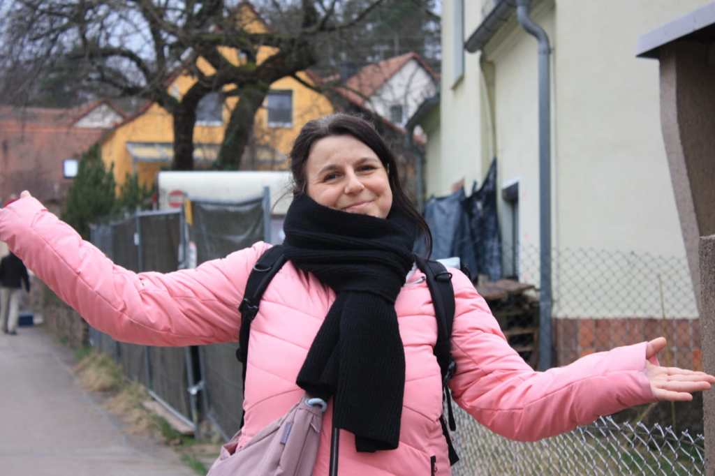 Frau mit rosa Winterjacke lächelt in Kamera