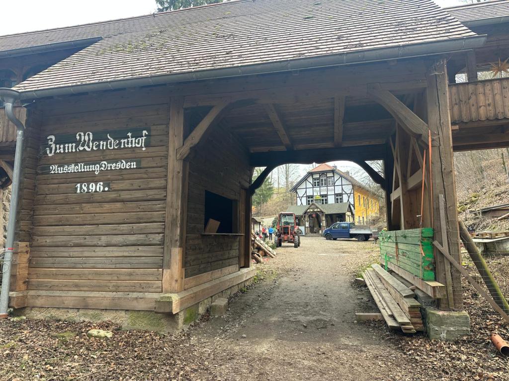 Durchgang mit Beschriftung "Zum Wendehof", dahinter Haus und Traktor