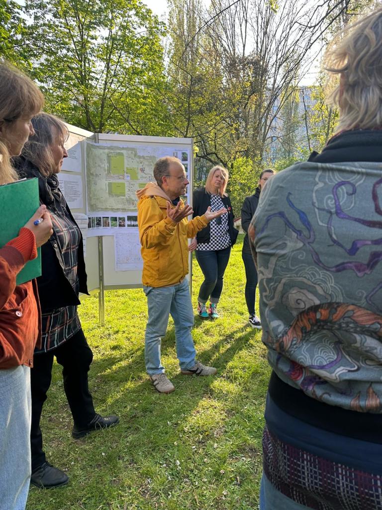 Mann steht auf Wiese vor Schautafeln