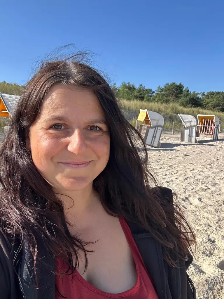 Frau an einem Strand mit Strandkörben