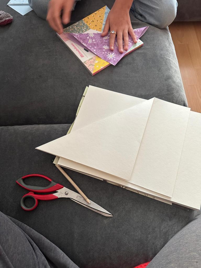 weißes und buntes Papier auf dem Sofa und Schere