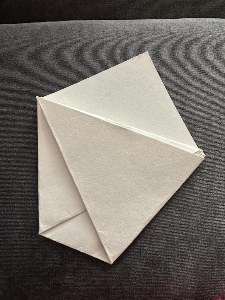 Zu einer kleinen Tüte gefaltetes Papier